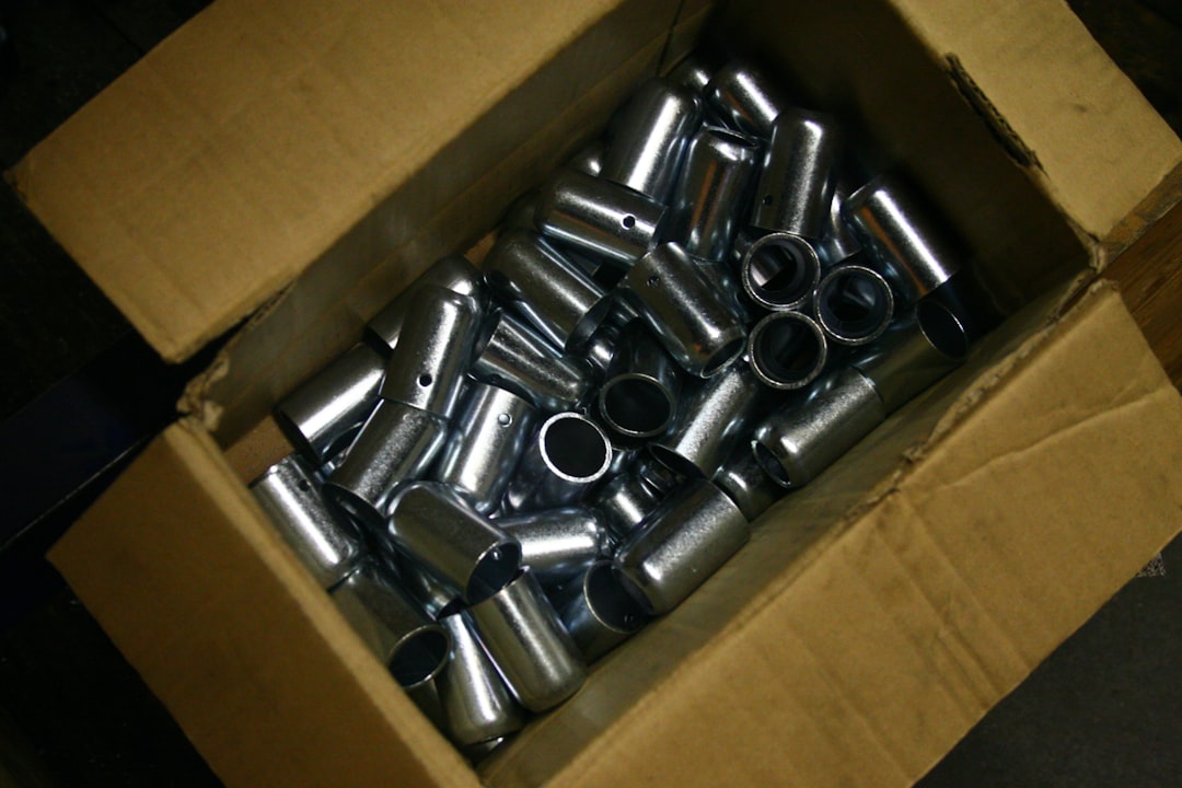 corrugated packaging - Cardboard box filled with shiny metal cylinders