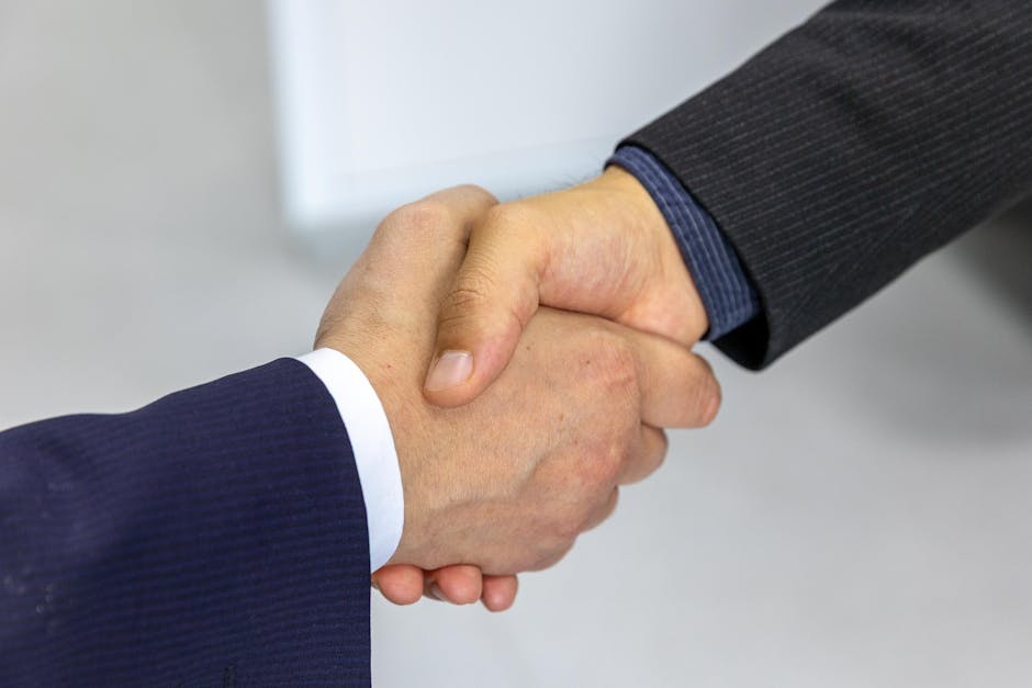 packaging news April 2026 - Close-up of two businessmen shaking hands, symbolizing agreement and partnership.