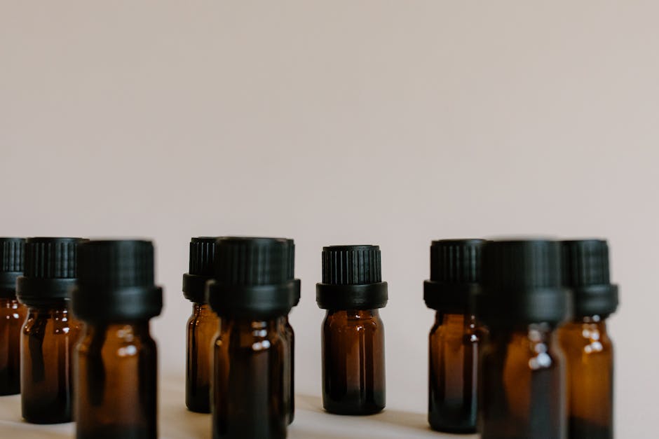 glass container specifications - A close-up of brown essential oil bottles arranged on a white surface with copy space.
