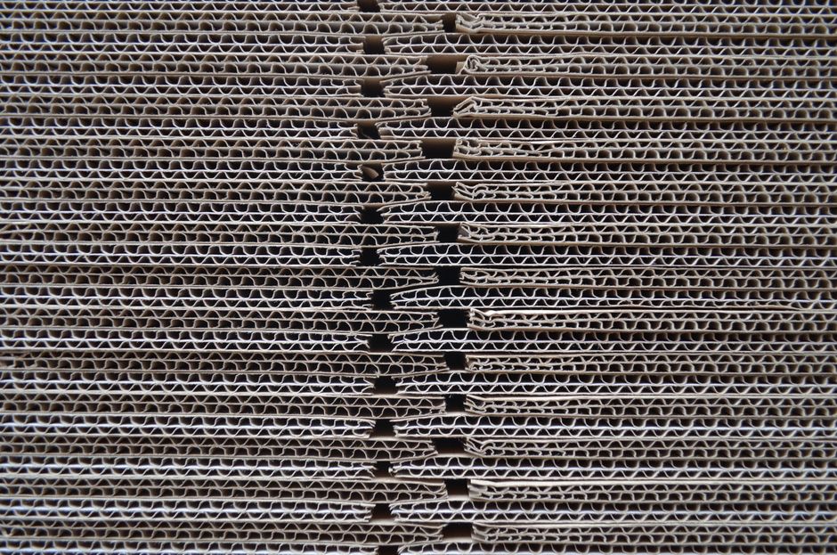 packaging industry news - Detailed close-up of corrugated cardboard stack showcasing its wavy texture and pattern.