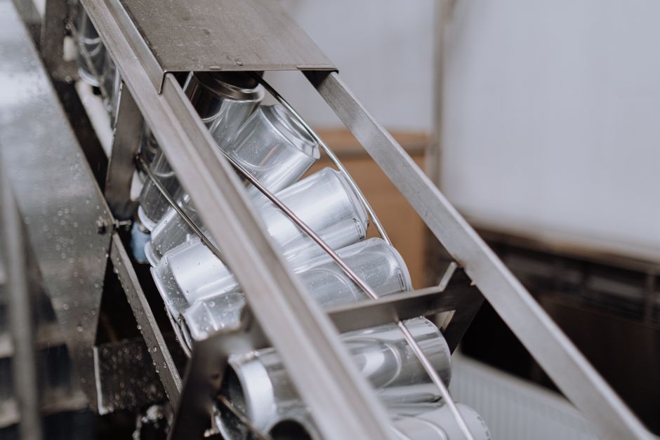 packaging industry news - Close-up of automated canning equipment in a brewery showcasing production efficiency.